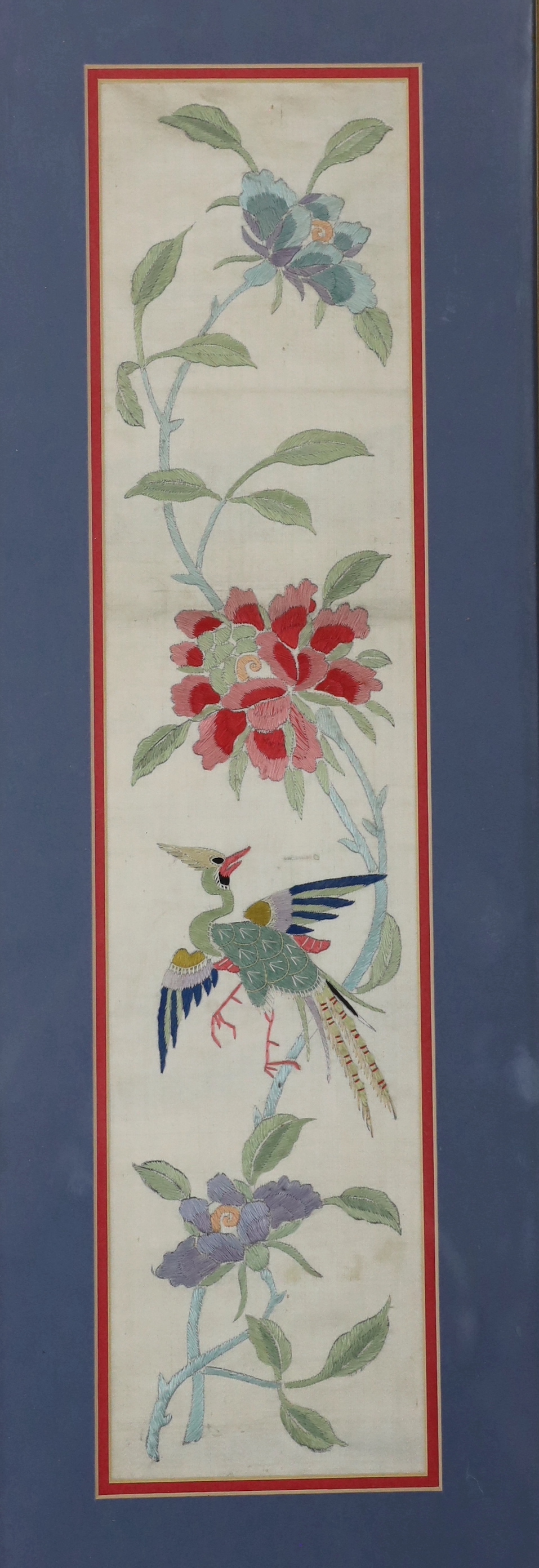 A pair of framed early 20th century Chinese cream silk polychrome silk embroidered sleeve bands, 11cm wide x 49cm long not including mount or frame